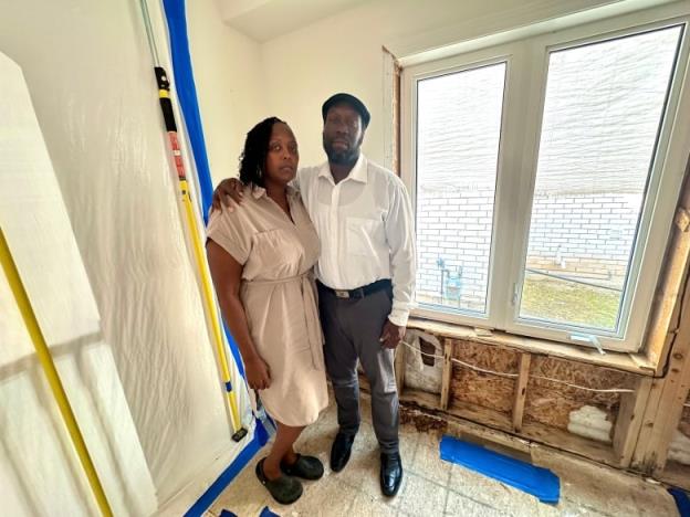 couple stands in room in disrepair